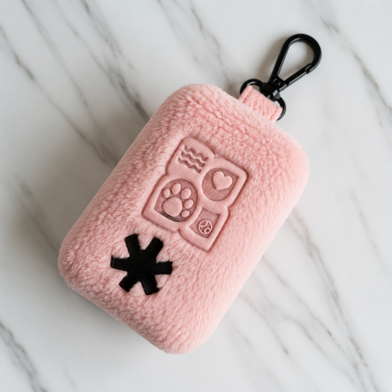 Pink fuzzy pouch with black clasp and embroidered symbols on marble background