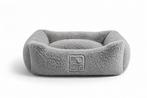 A gray, plush pet bed with a cushioned interior and embossed logo on the front